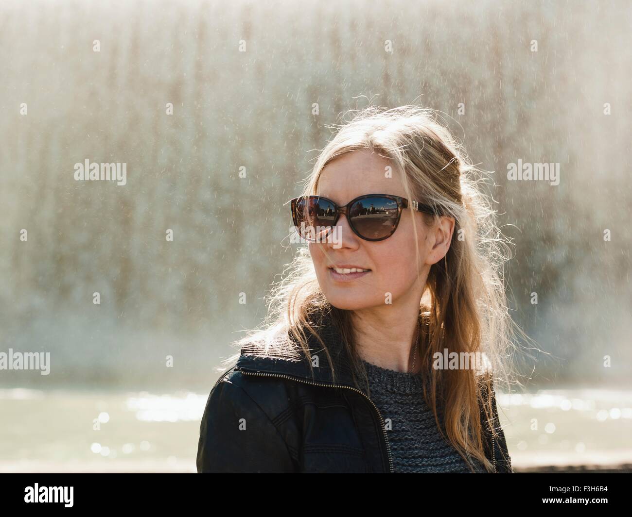 Portrait of mid adult woman wearing sunglasses in front of fontaine sur la Colline de Montjuic, Barcelone, Espagne Banque D'Images