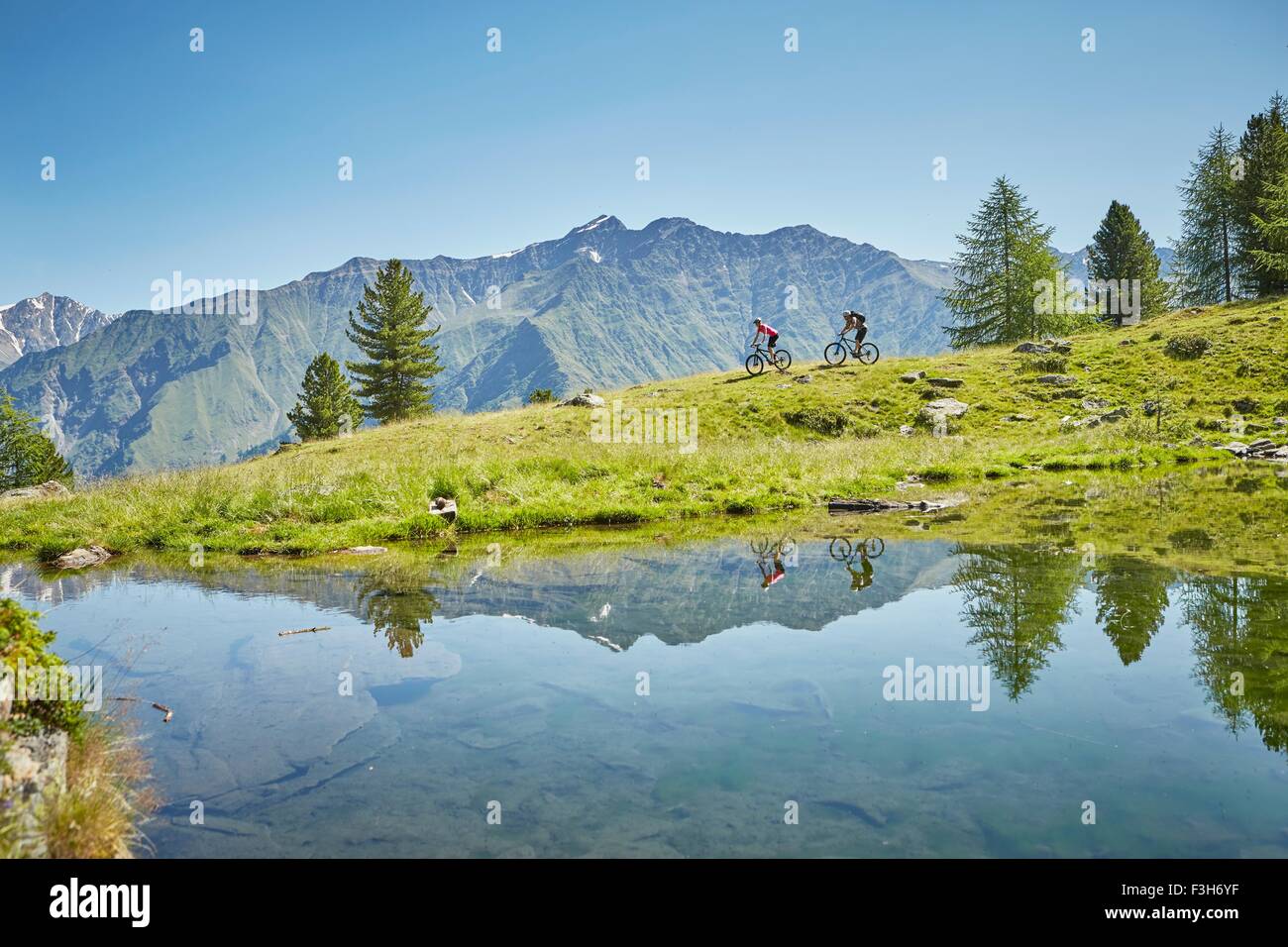 Jeune couple vtt en bas de la colline, Karthaus, Val Senales, Tyrol du Sud, Italie Banque D'Images
