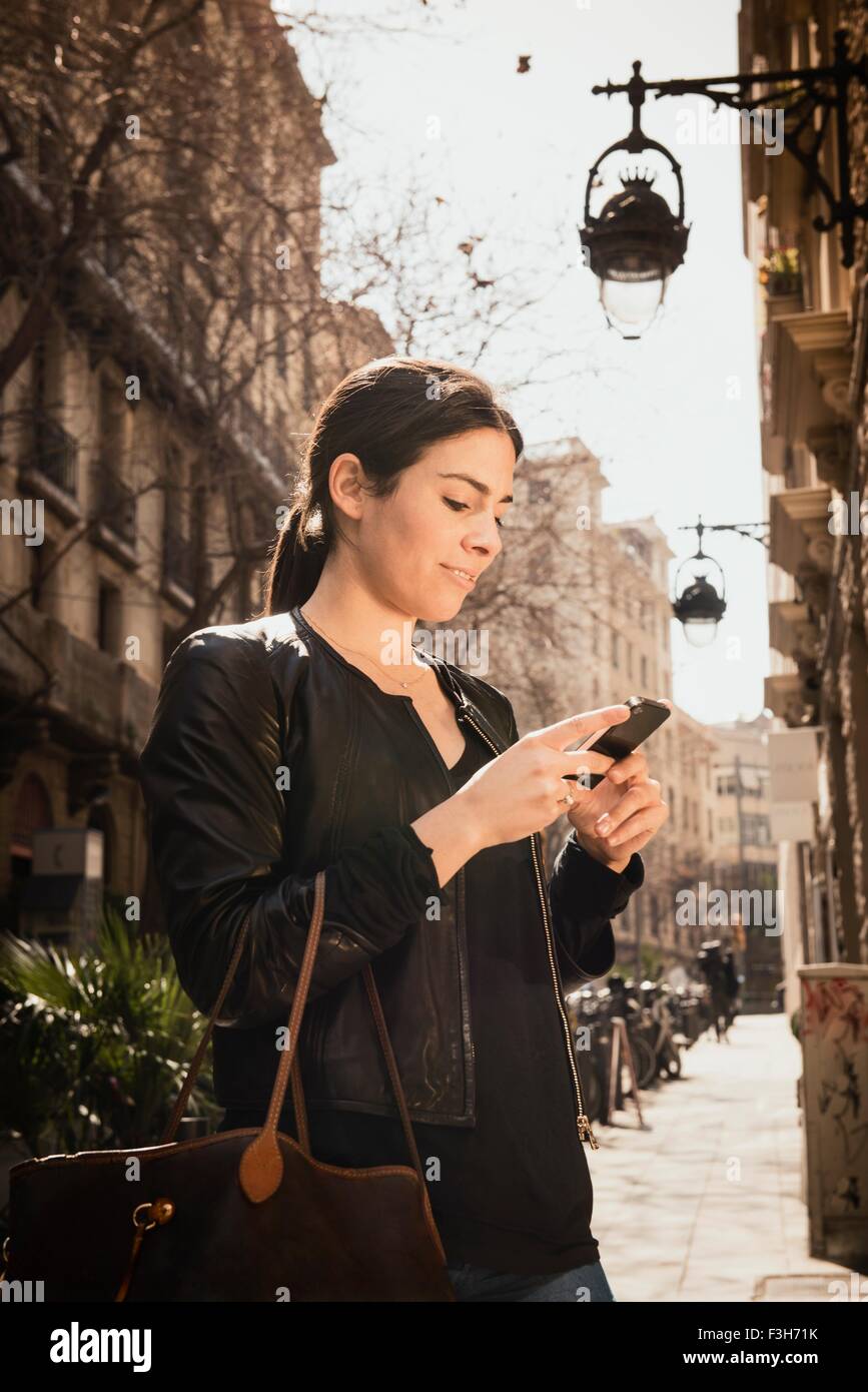 Femme à l'aide du smartphone sur le street, El Born, Barcelone, Espagne Banque D'Images
