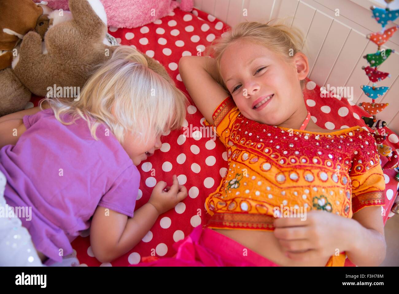 Portrait de deux jeunes sœurs lying on bed Banque D'Images