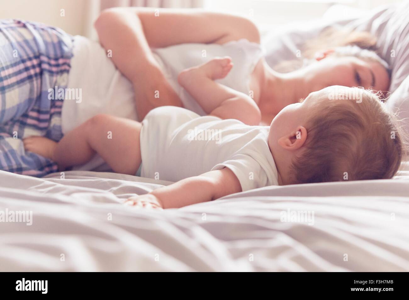 Mère et bébé garçon reposant sur le lit Banque D'Images