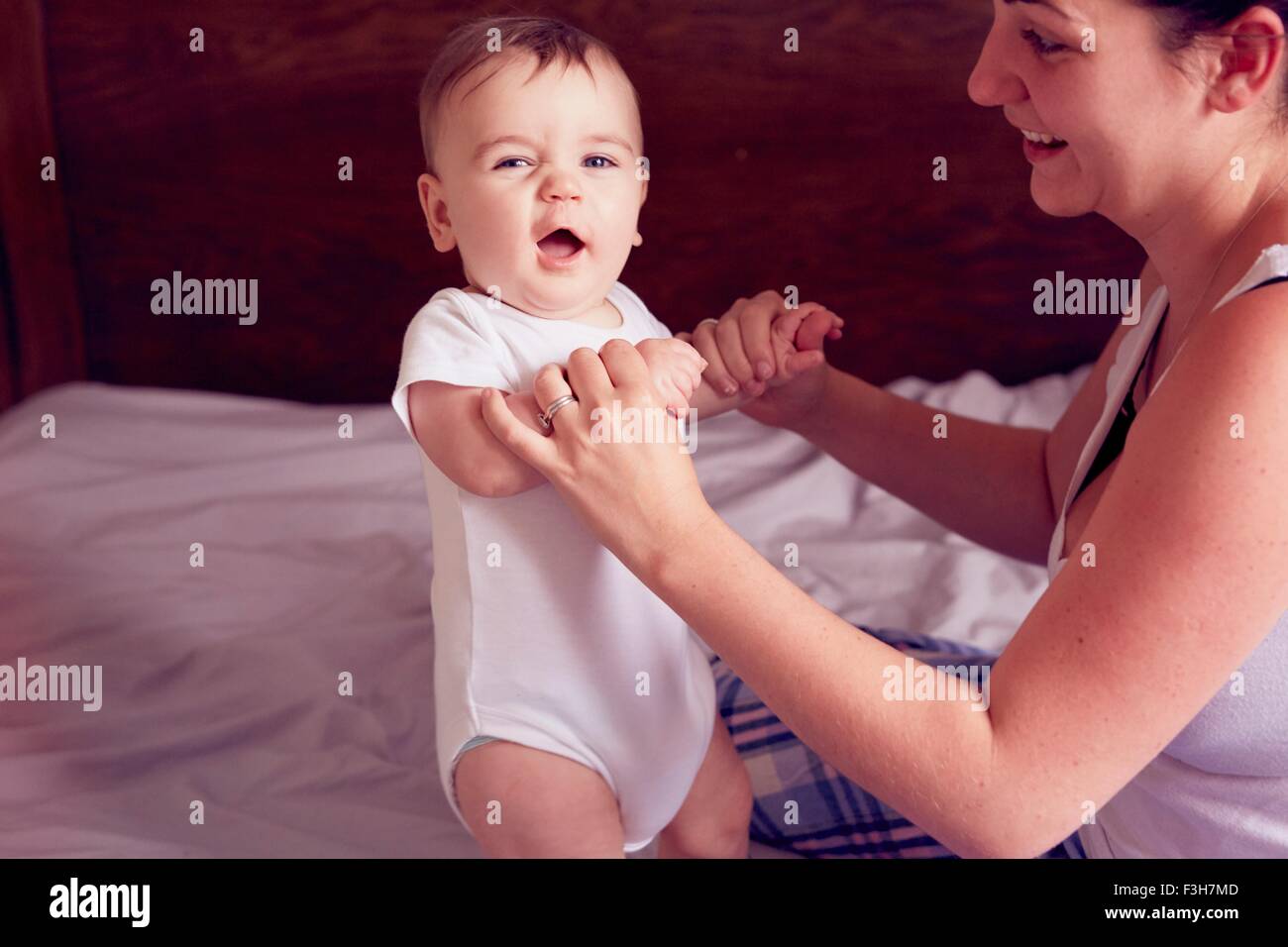 Mère et bébé boy playing on bed Banque D'Images
