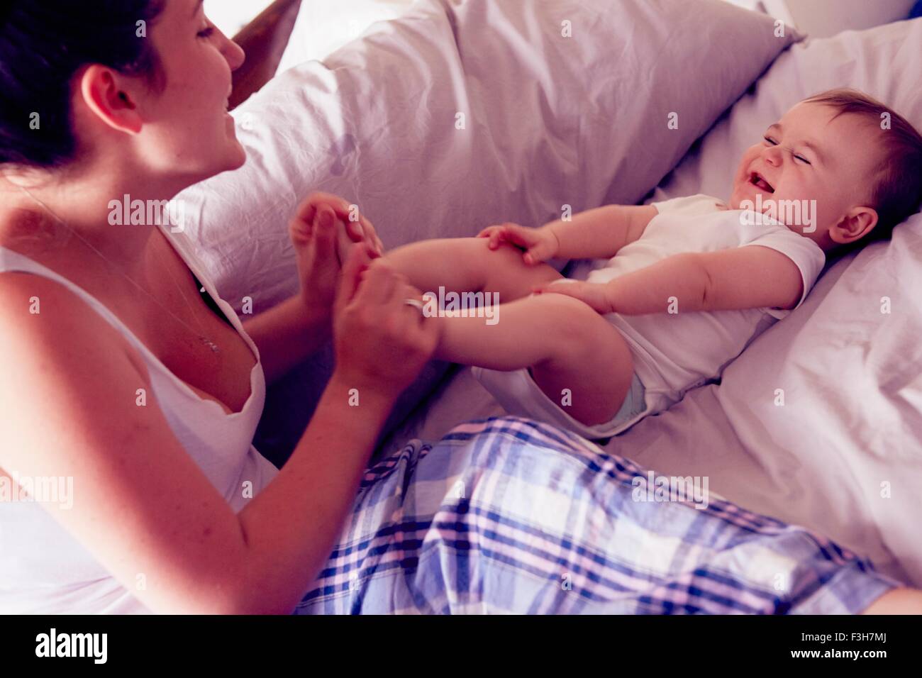 Mère et bébé boy playing on bed Banque D'Images