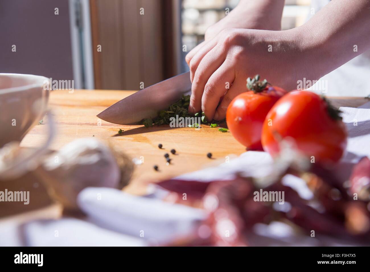 Mains de femme au comptoir de la cuisine en tranches fines herbes Banque D'Images