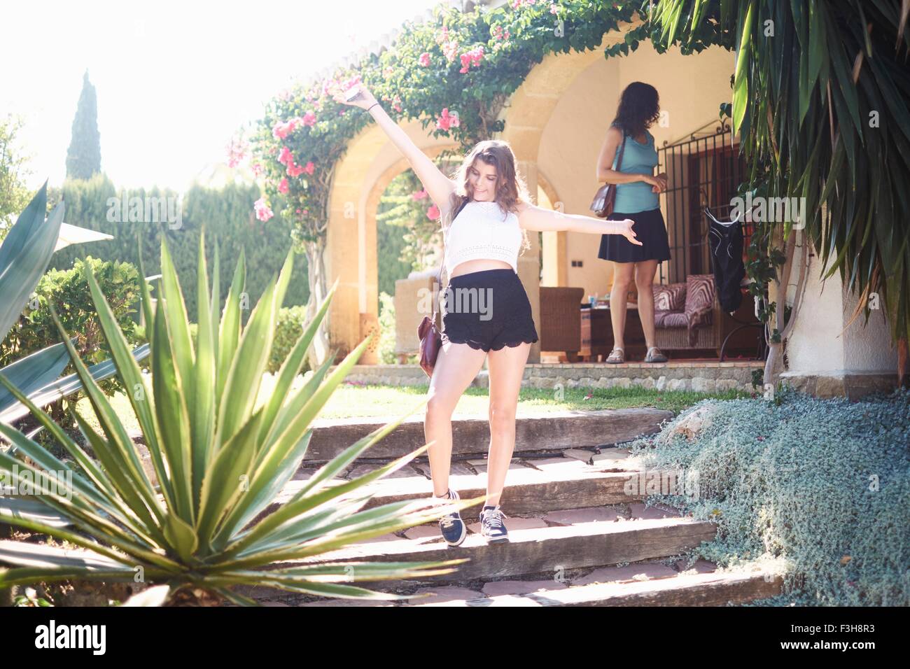 Teenage girl posing sur maison de vacances étapes avec les bras ouverts Banque D'Images