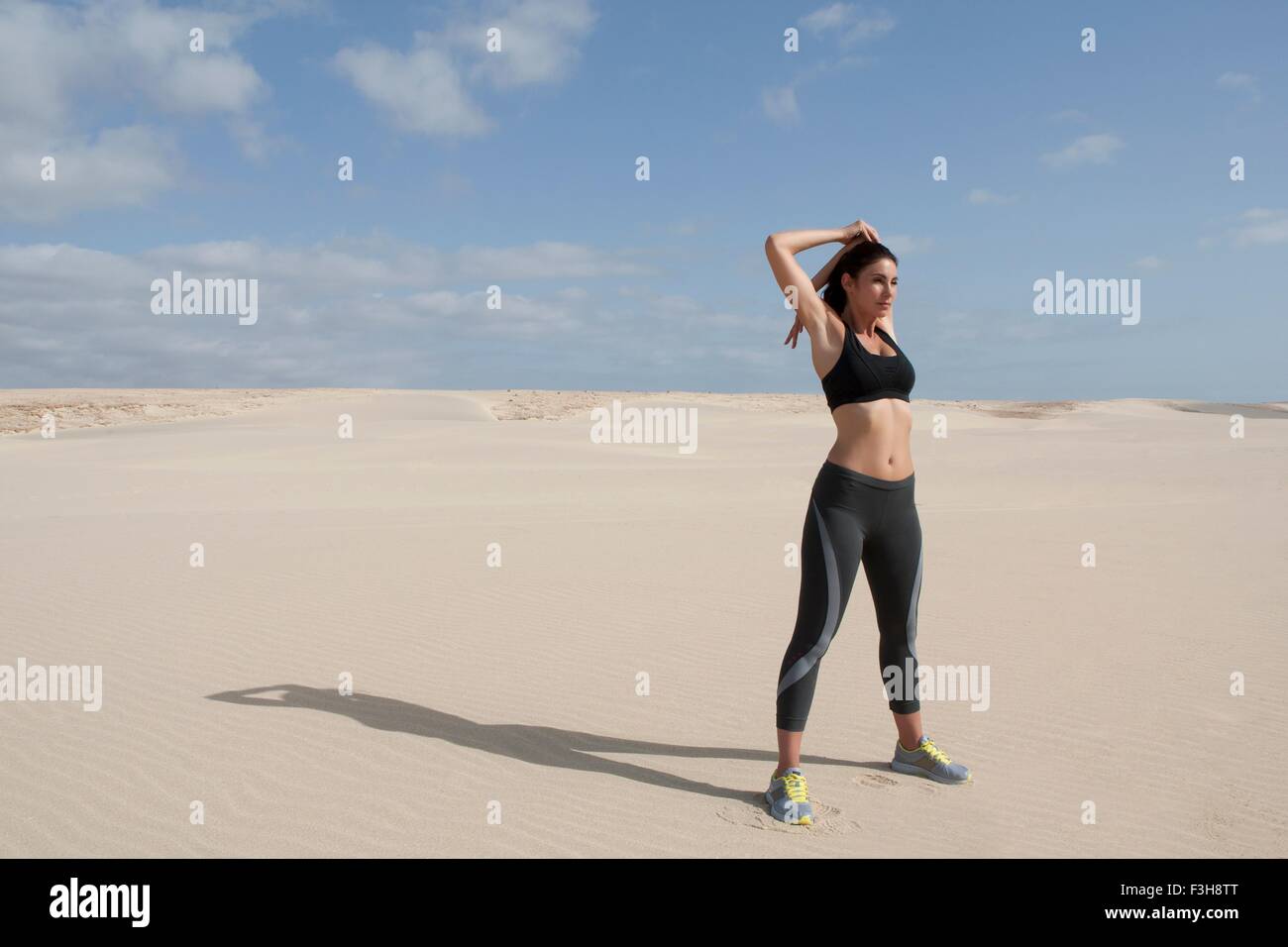 Mid adult woman exercising on beach Banque D'Images