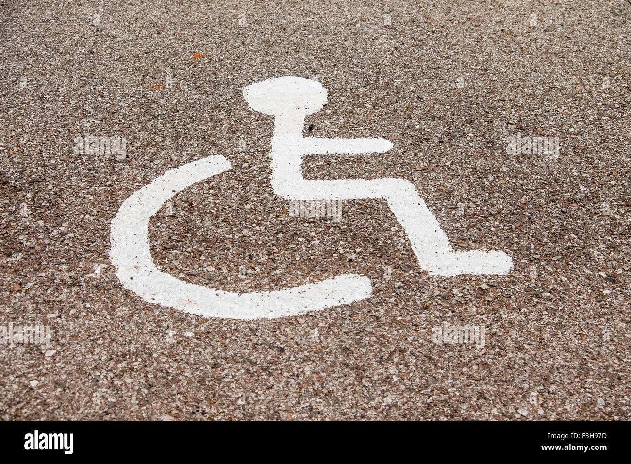 Peint sur une aire de stationnement pour handicapés symbole dans un parking. Banque D'Images
