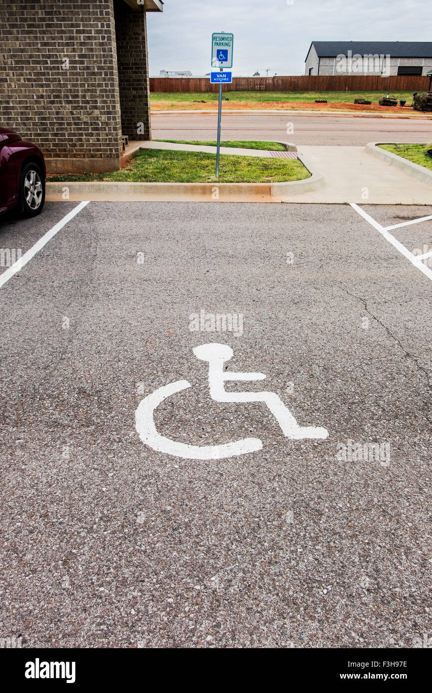 Un symbole peint sur les places de stationnement pour personnes handicapées dans un parking. Banque D'Images