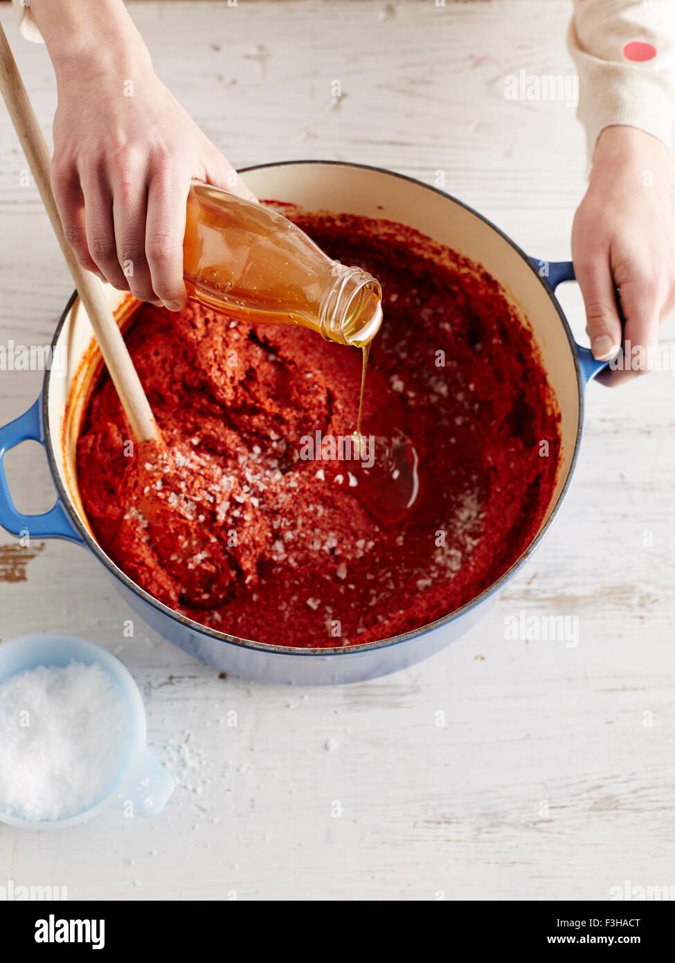 Vue de dessus de milieu liquide pour l'ajout de womans adultes gochuchang dans une casserole Banque D'Images