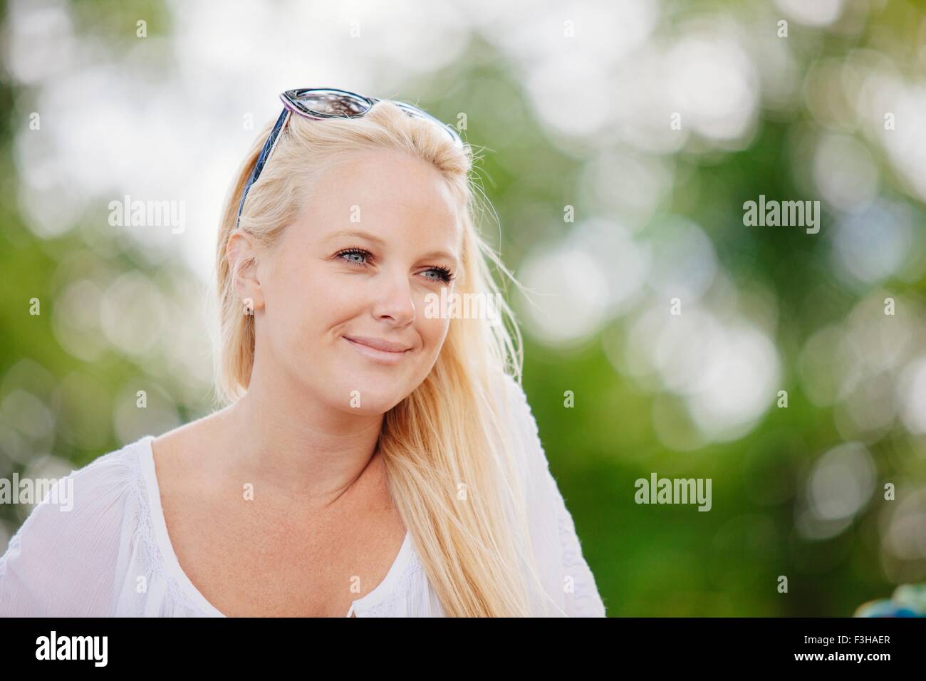 Portrait de jeune femme blonde aux cheveux longs avec des lunettes sur la tête à la voiture smiling Banque D'Images