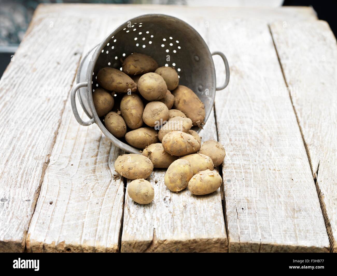 Nature morte de pommes de terre Jersey Royal dans une passoire sur table en bois Banque D'Images
