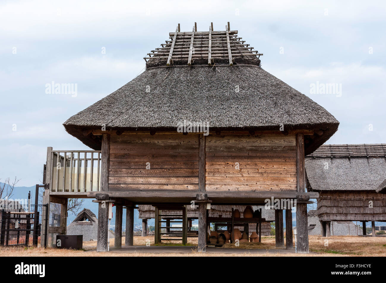 Yoshinogari Park, au Japon. Règlement Yayoi reconstruit. Minami no Mura, village du sud. Prix magasin soulevées avec toit de chaume. Ciel couvert ciel gris. Banque D'Images