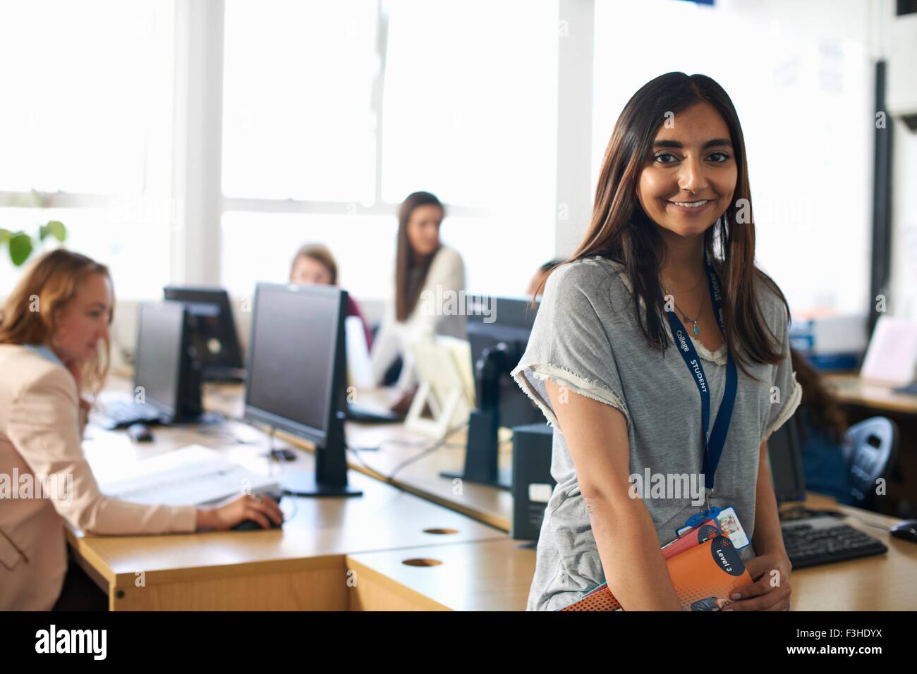 Portrait of smiling female student holding file dans la classe Banque D'Images