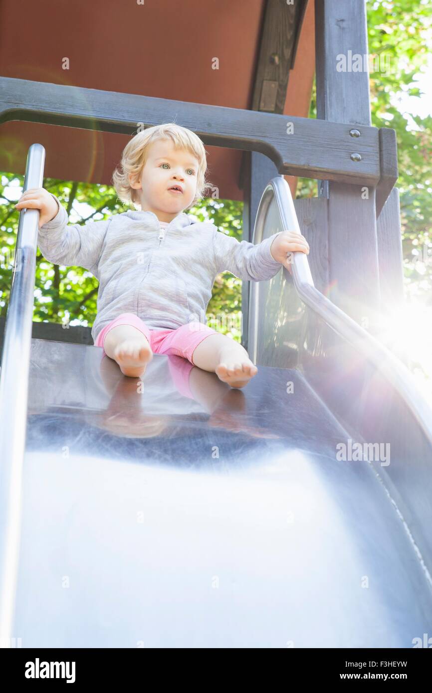 Female toddler jouant sur park slide Banque D'Images