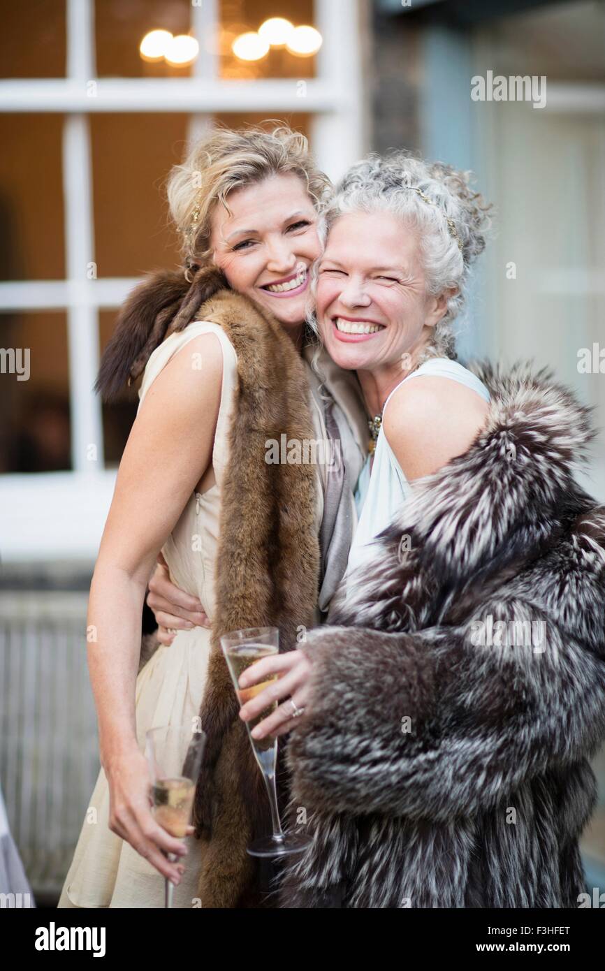 Les femmes matures élégantes bénéficiant du champagne en jardin urbain Banque D'Images