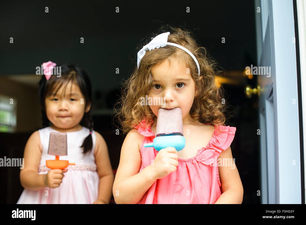 Deux jeunes filles eating ice lollies Banque D'Images