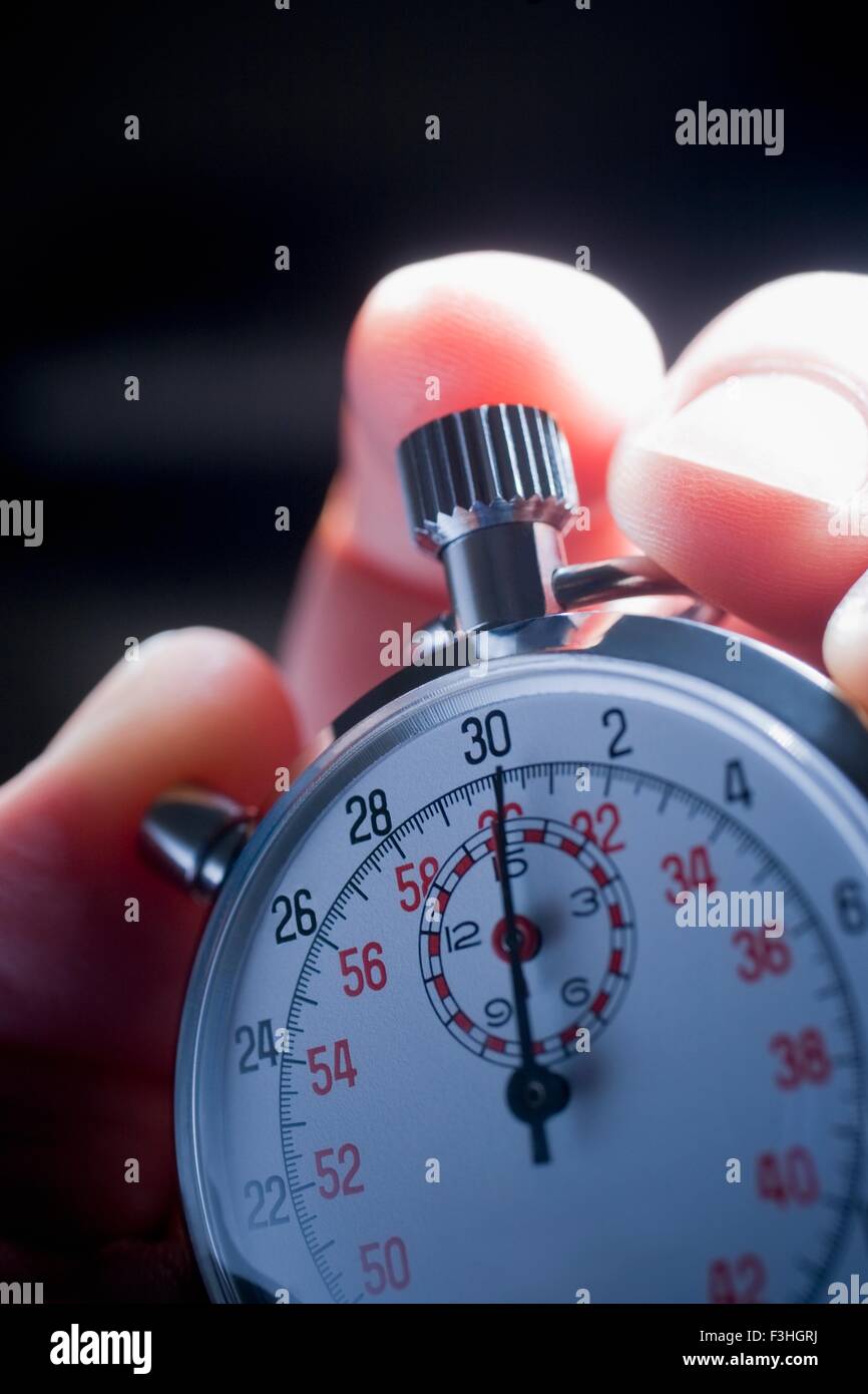 Cropped shot of hand holding silver stop watch Banque D'Images