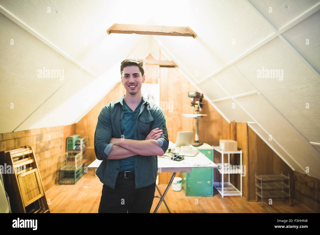 Jeune homme debout dans l'espace, les bras croisés, smiling at camera Banque D'Images