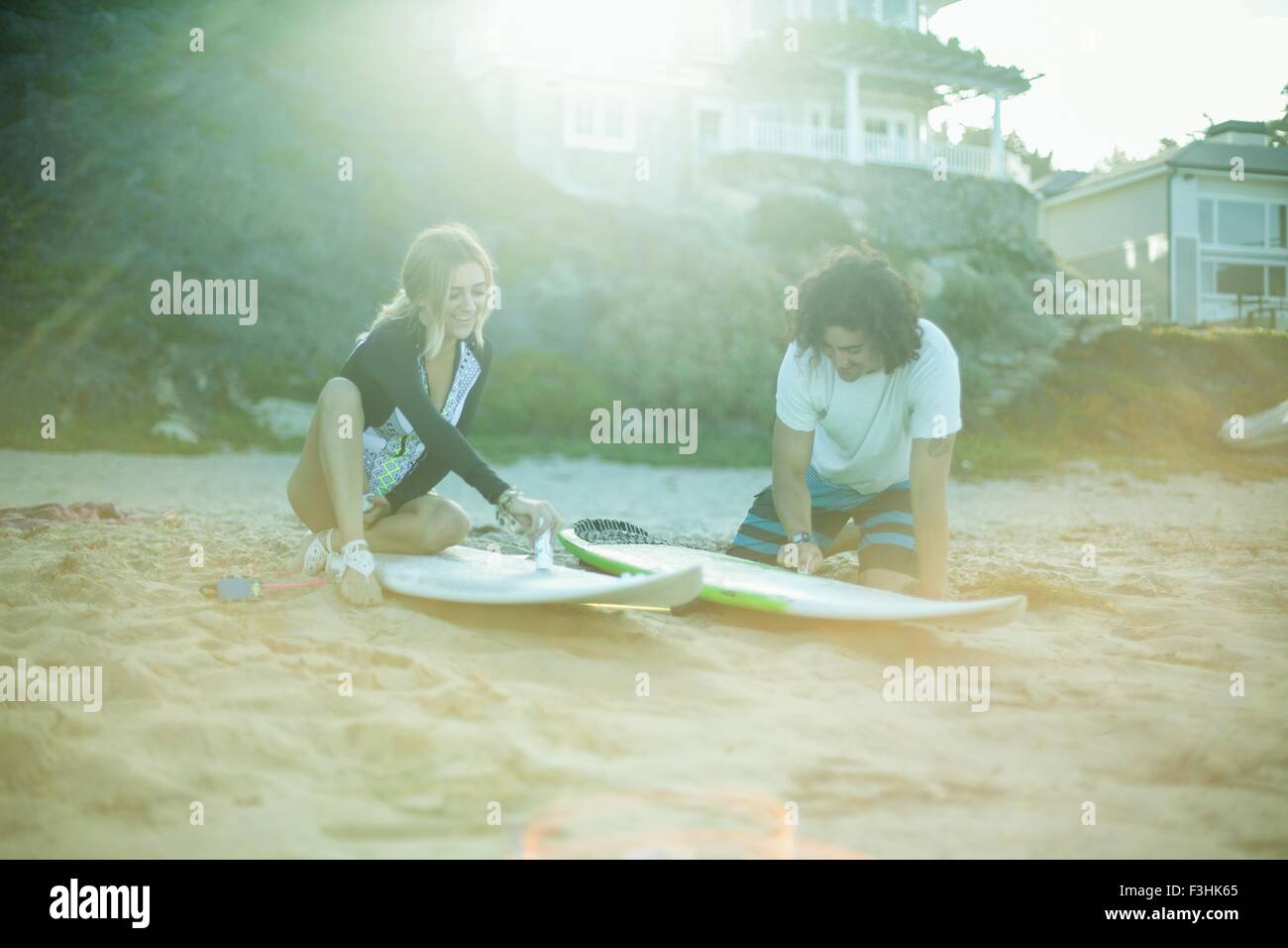 Couple sitting on beach, fartage surboards Banque D'Images