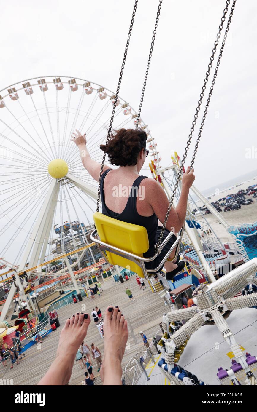 Woman waving balançoires d'un parc d'attractions Banque D'Images