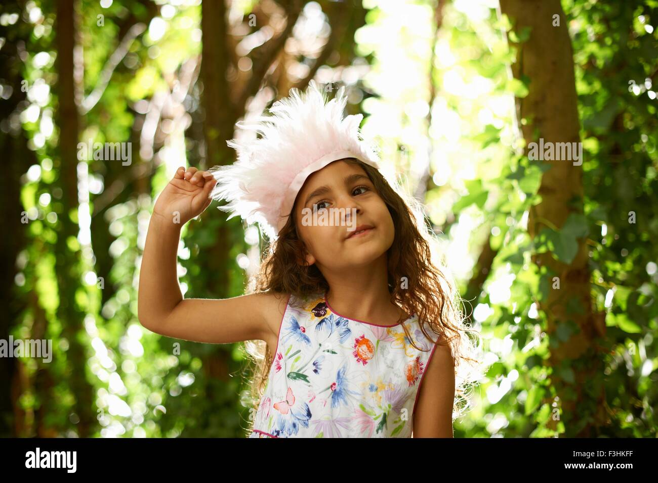 Portrait de jolie fille portant une coiffe de plumes dans la forêt Banque D'Images