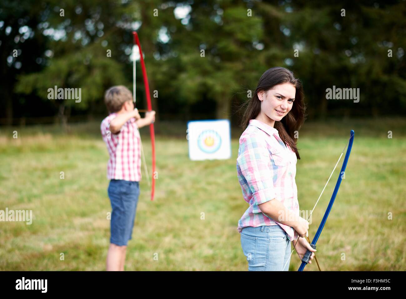 Portrait of teenage girl practicing archery avec frère Banque D'Images