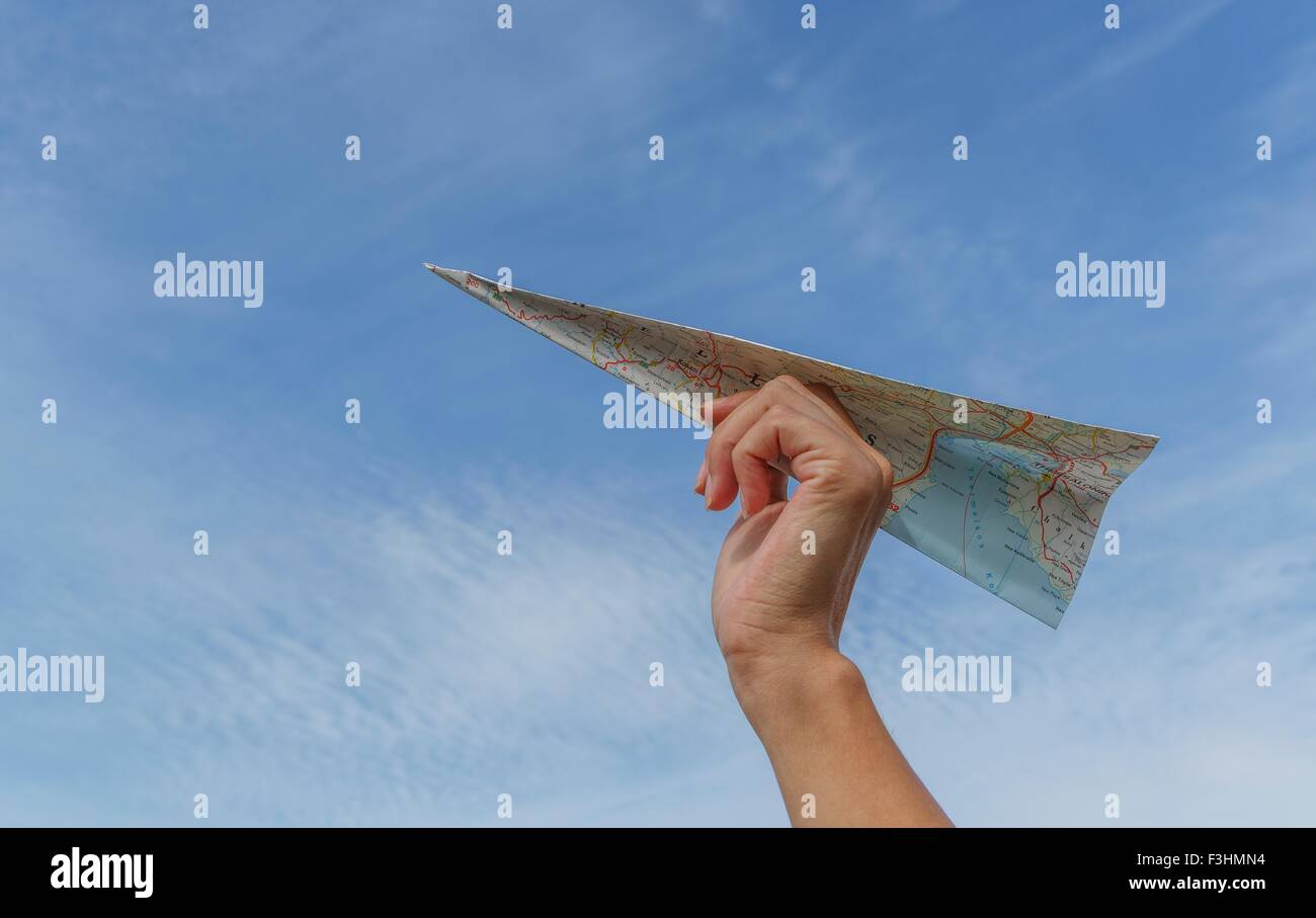 Low angle view de ciel bleu et de tenir la main de womans avion en papier fabriqué à partir de la carte Banque D'Images