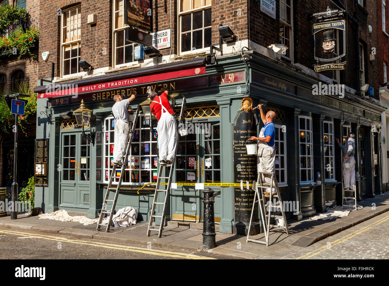 Les peintres et décorateurs peinture extérieure d'un pub, Shepherd Market, London, UK Banque D'Images