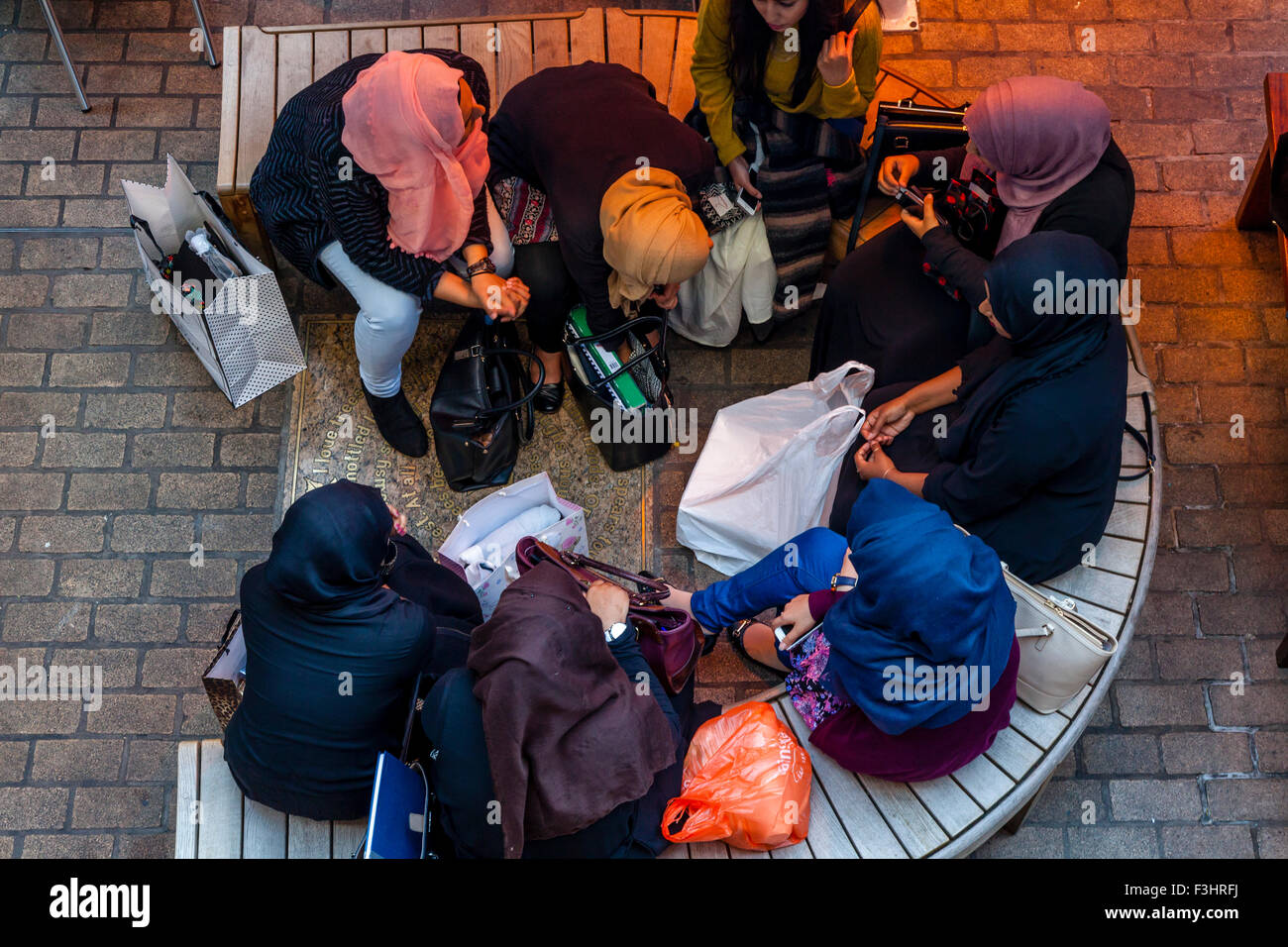 Jeunes femmes musulmanes Chat assis dans un café à Carnaby Street, London, UK Banque D'Images