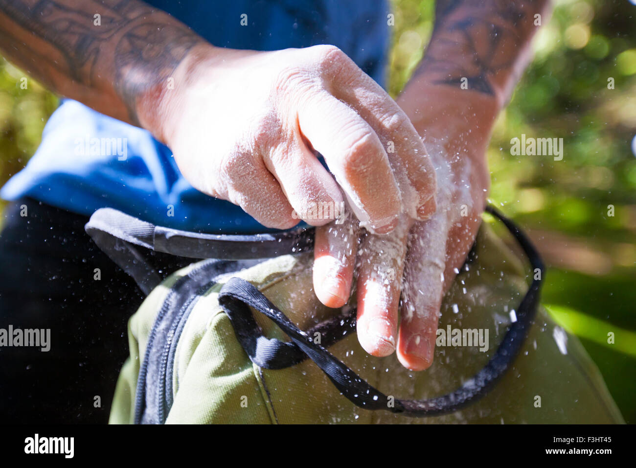 Un grimpeur frotte la craie sur les mains avant de grimper. Banque D'Images