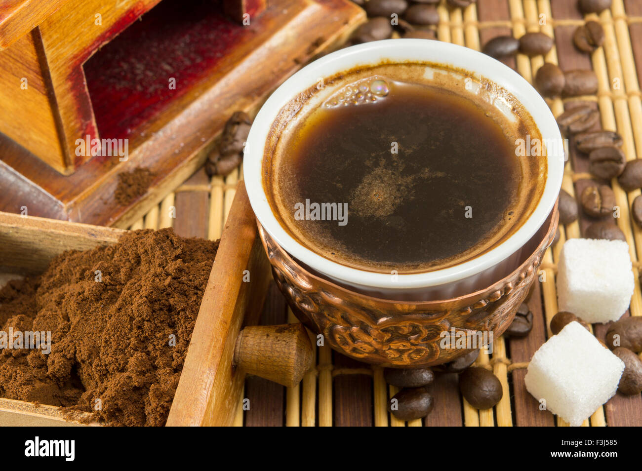 Tasse de café avec du sucre et les grains de café, à côté de café dans un tiroir grinder Banque D'Images