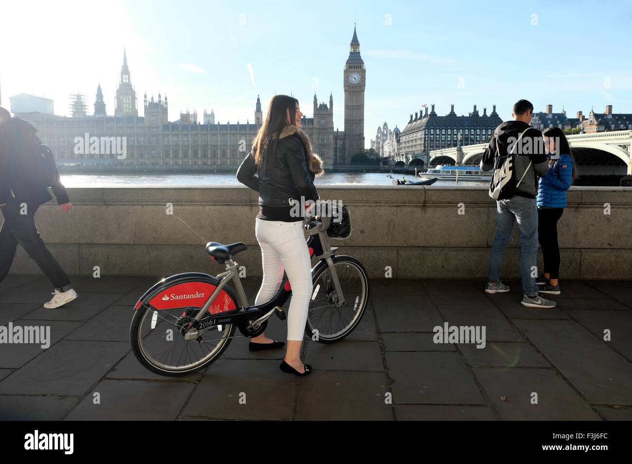 Jeune femme équitation tourisme Santander voitures vélo sur rue au pont de Westminster Big Ben et des chambres du Parlement et Tamise London UK KATHY DEWITT Banque D'Images