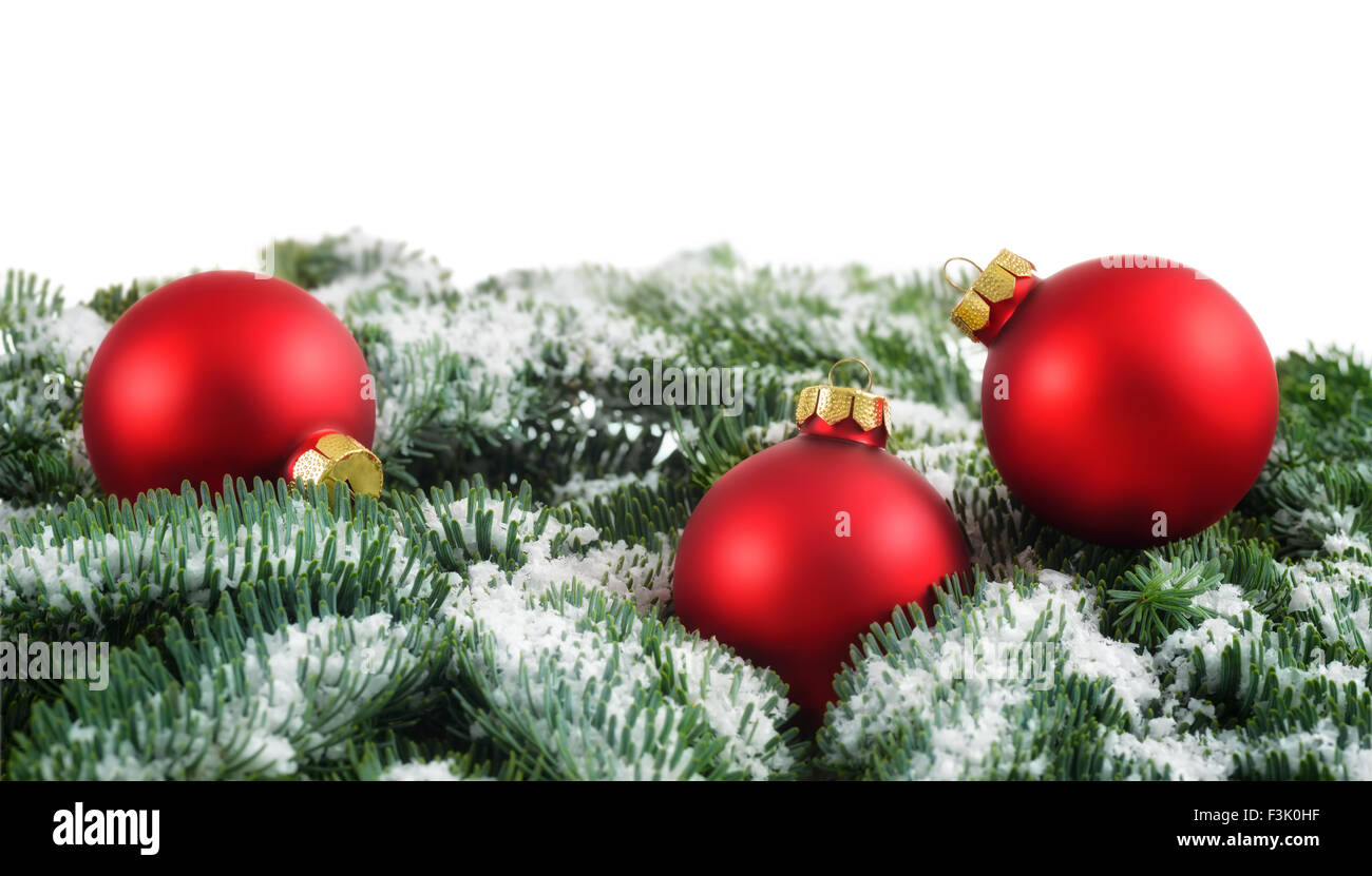 Arrangement de Noël simple avec des boules rouges sur des brindilles de sapin, studio shot isolé sur fond blanc Banque D'Images