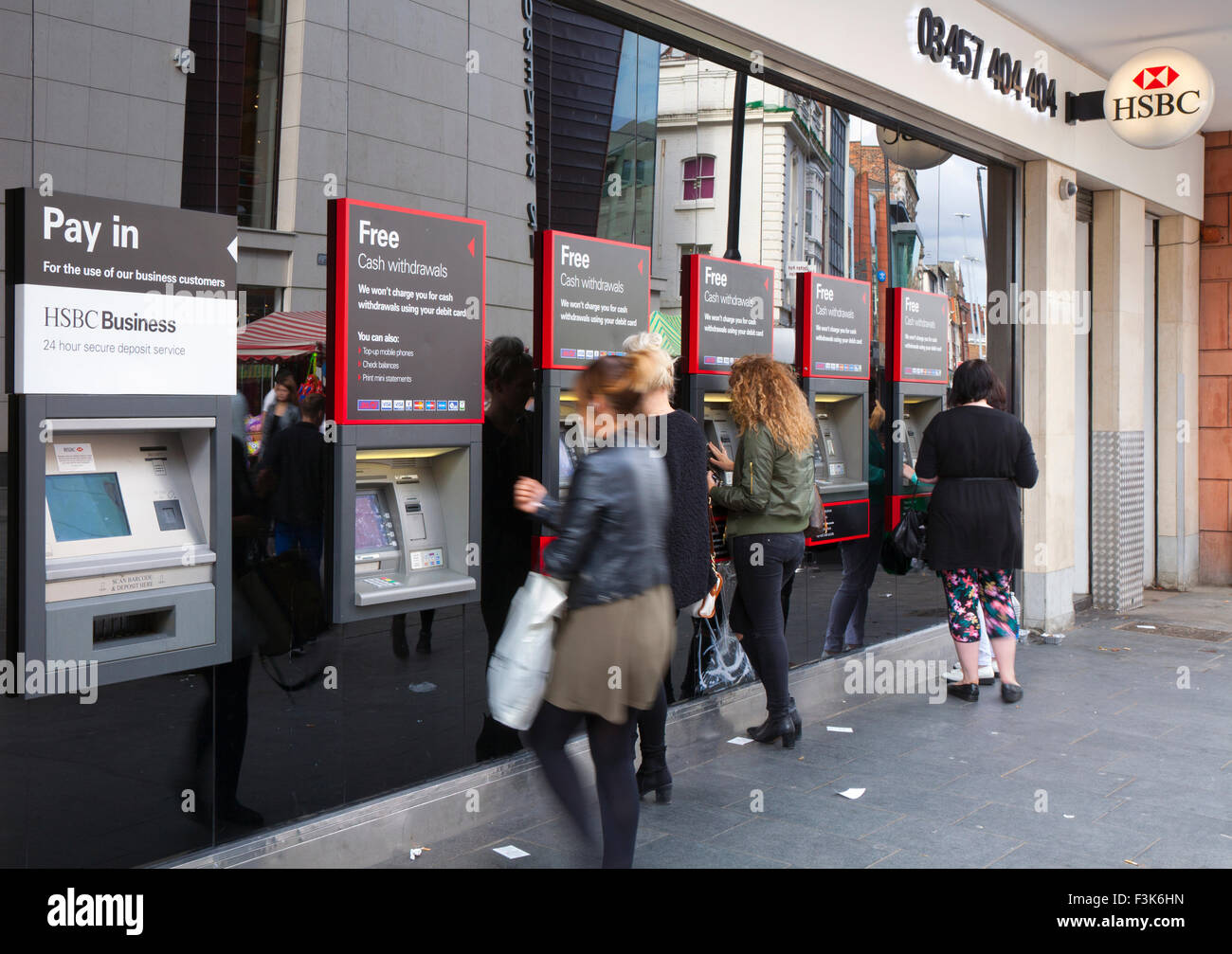 Rangée de clients, et un guichet automatique ou un trou-dans-le-mur des machines en dehors des banques HSBC, Liverpool, Merseyside, Royaume-Uni Banque D'Images
