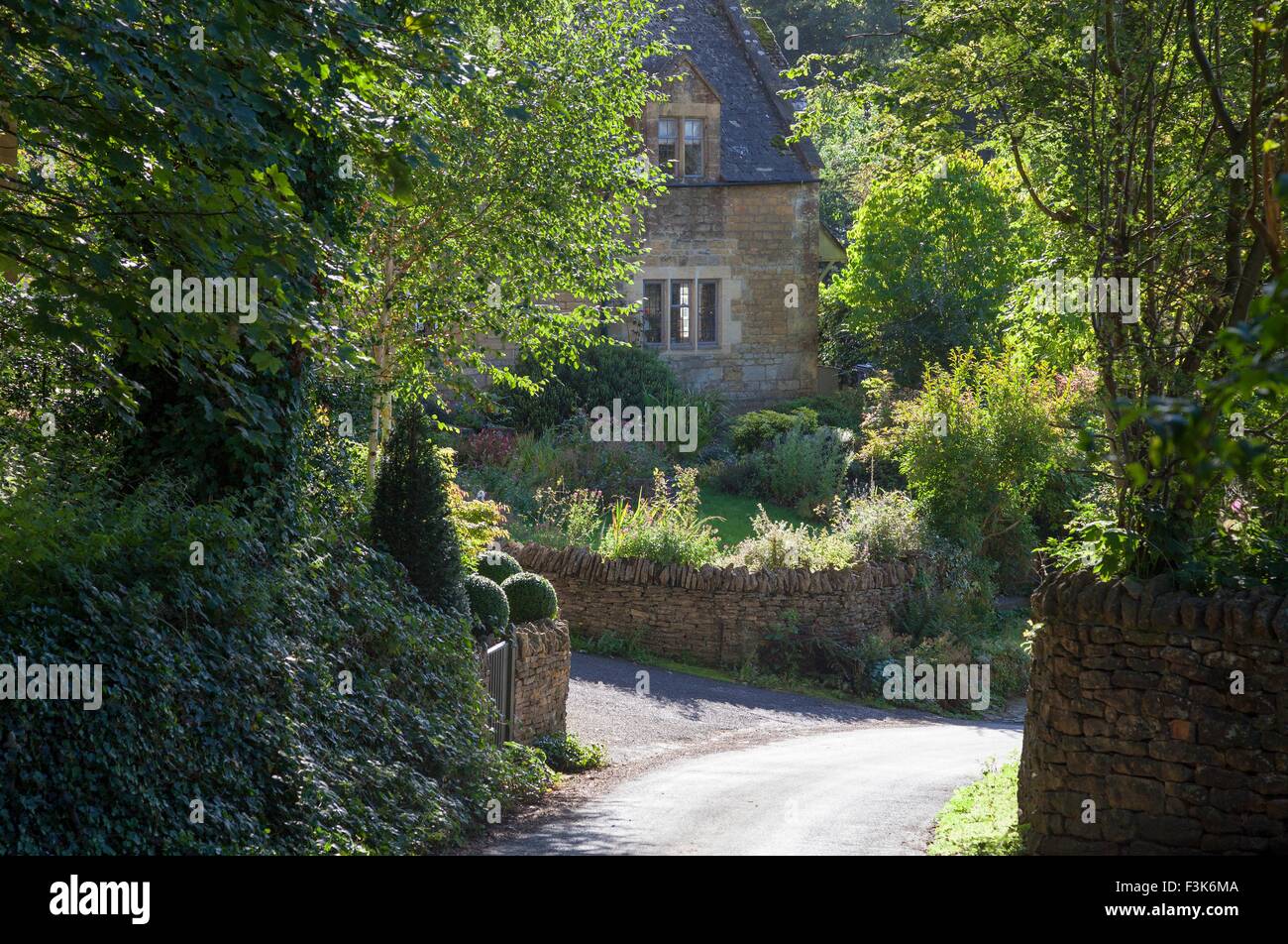 Pretty Cotswold House vers le bas une route de campagne, Worcestershire, Angleterre. Banque D'Images