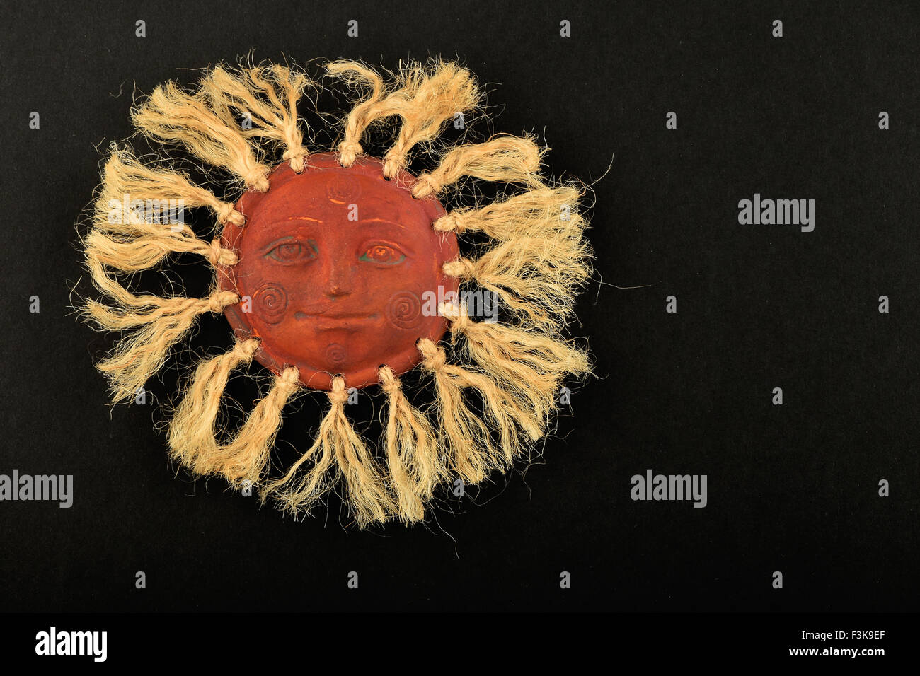 Céramique traditionnelle mexicaine sun happy face plaque de symboles avec rayons de corde de jute isolated on black Banque D'Images