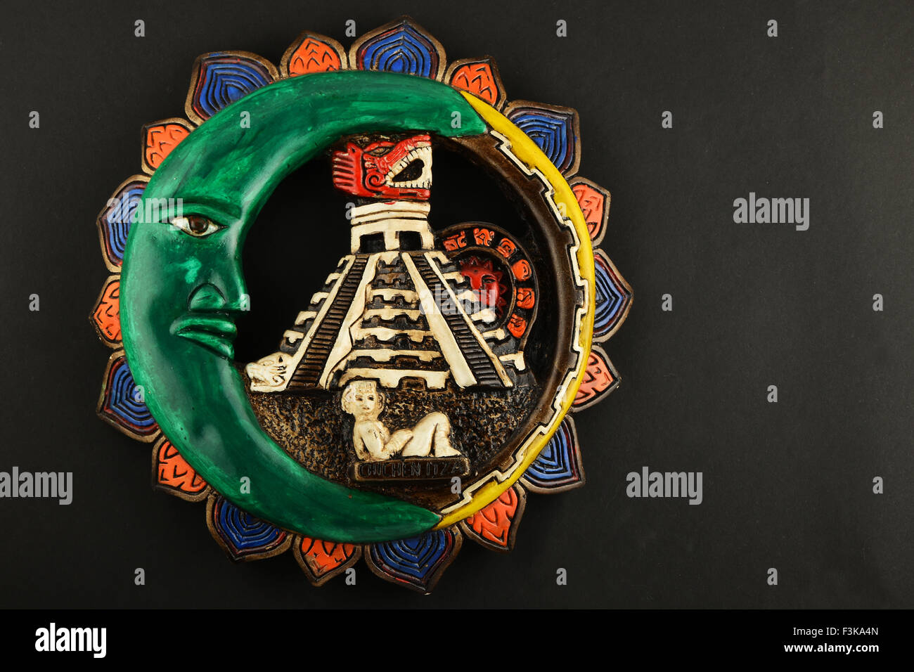 Souvenir Maya mexicaine Chichen Itza avec plaque céramique peint de lune, pyramide et fille isolée sur papier noir Banque D'Images