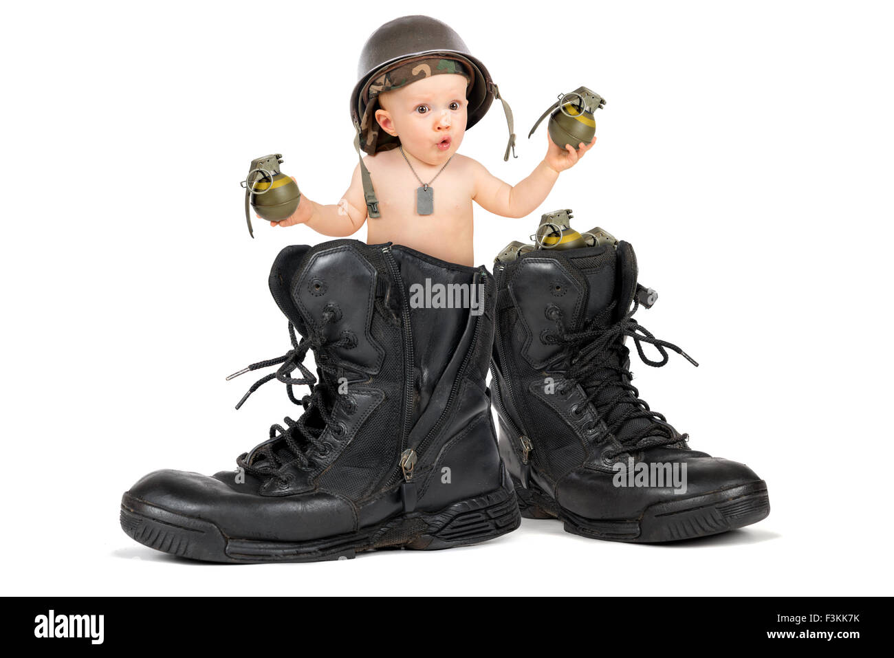Cute baby girl à l'intérieur d'une botte militaire avec des grenades Banque D'Images
