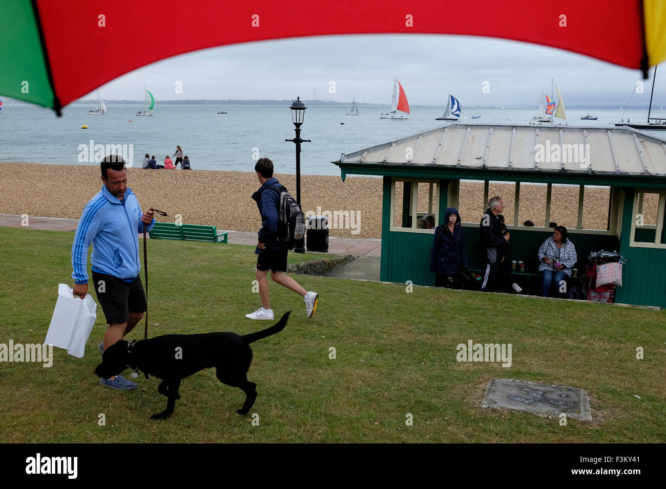 En 2015, la semaine de Cowes, île de Wight n'marcheurs dans la pluie le Green à l'abri de la pluie Yacht Racing, animations côté rive, bandes, Yacht Club scènes, 2015, la semaine de Cowes, île de Wight, Angleterre, Royaume-Uni, Banque D'Images