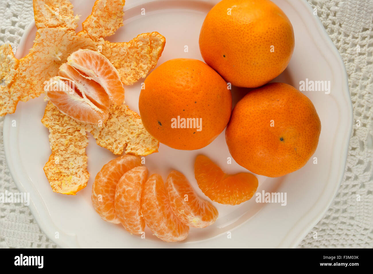 Les oranges juteuses sur une plaque blanche avec pèle Banque D'Images