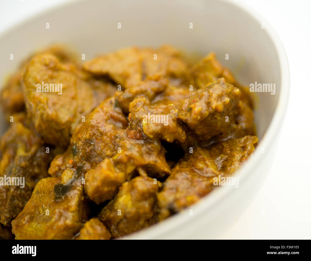 Viandé curry à l'indienne dans un bol blanc contre blanc Banque D'Images