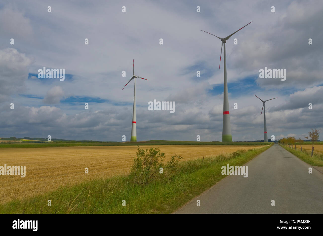 Certaines éoliennes en paysage agricole avec blue cloudy sky Banque D'Images