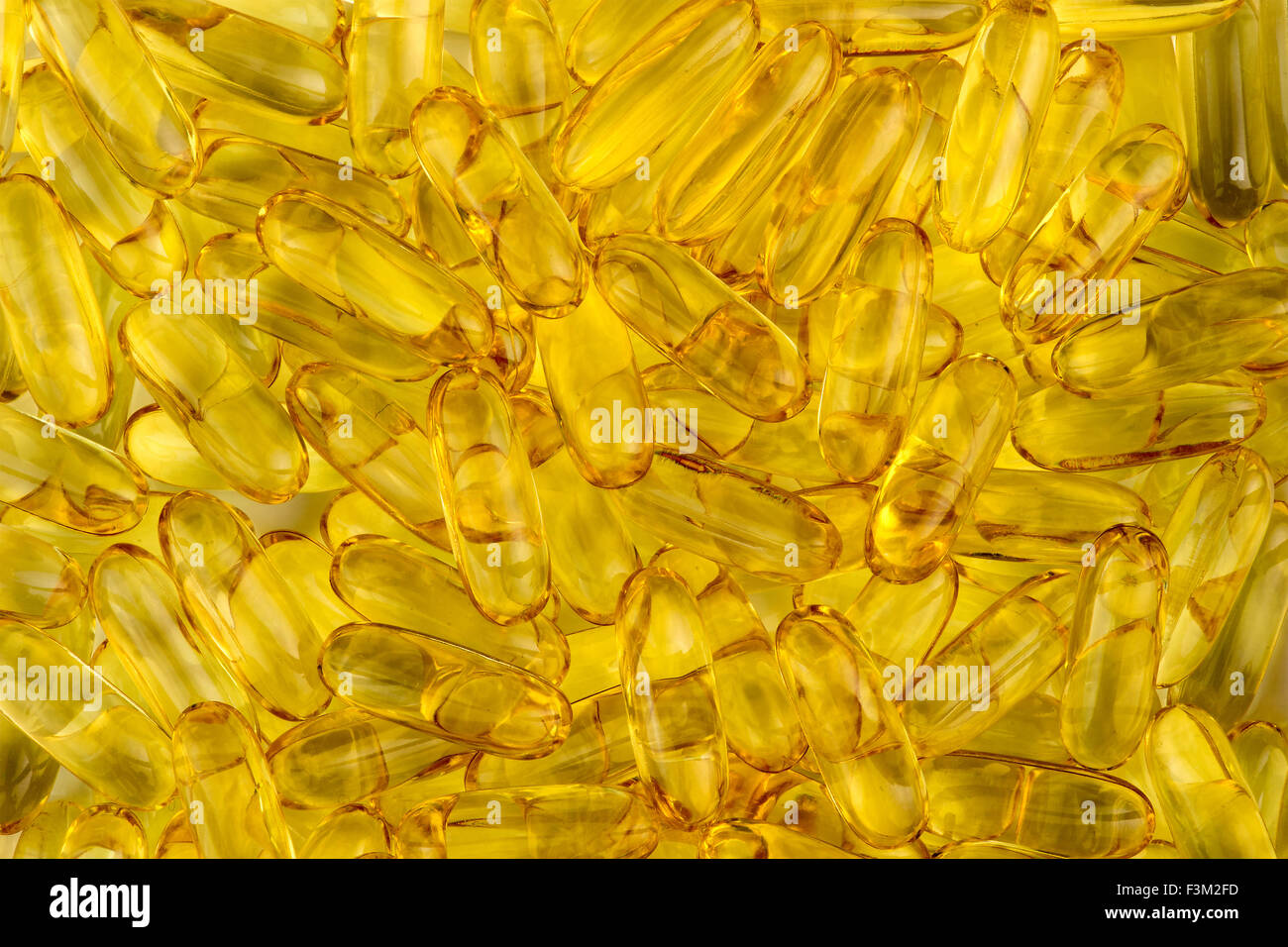 La texture de fond jaune acide gras d'omega des capsules d'huile de poisson Banque D'Images