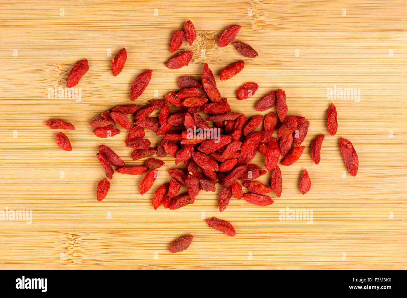 Pile de baies de goji sec sur une planche en bois Banque D'Images