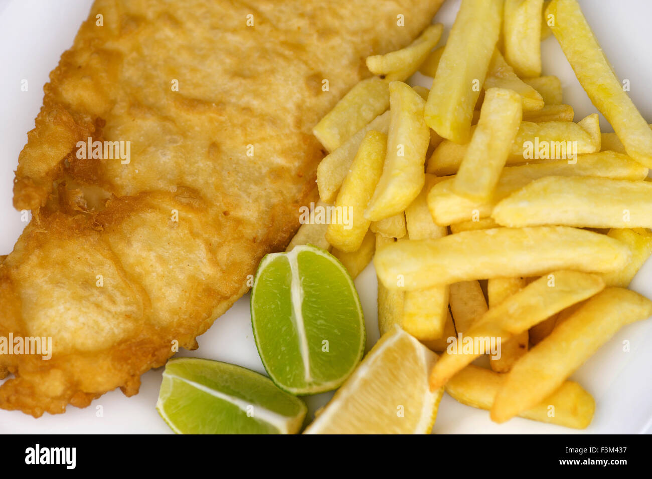 Vue de dessus de la farine de poisson et frites traditionnelles avec des frites, poissons et battues tranches de lime et de citron Banque D'Images