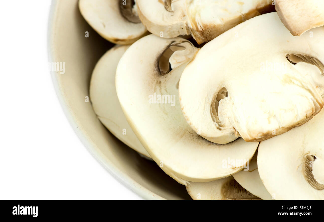 Gros plan macro de champignons blancs tranchés dans un bol commun isolé sur fond blanc Banque D'Images