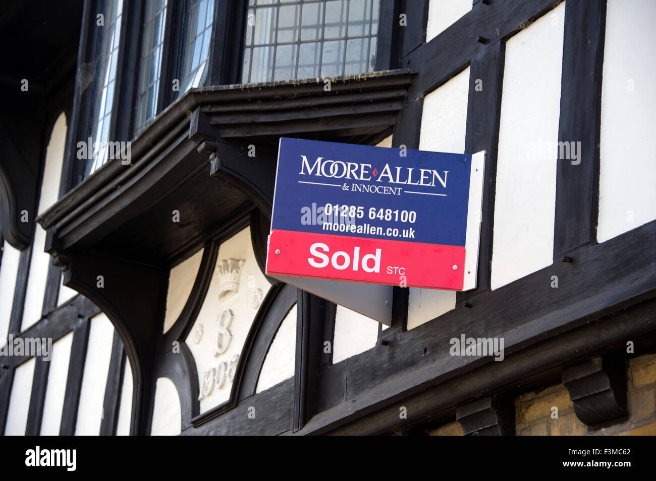 Un pour l'agent immobilier vente signe sur un 1908 de style Tudor, maison à colombages dans une rue de Cirencester, Gloucestershire, Royaume-Uni. un Banque D'Images