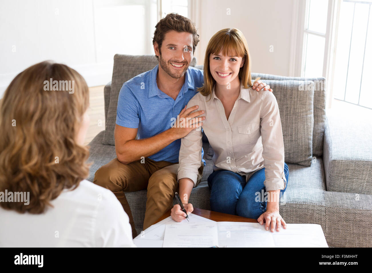 Jeune couple propriétaire réunion agent immobilier pour investissement maison. La signature d'un contrat. Appareil photo face Banque D'Images
