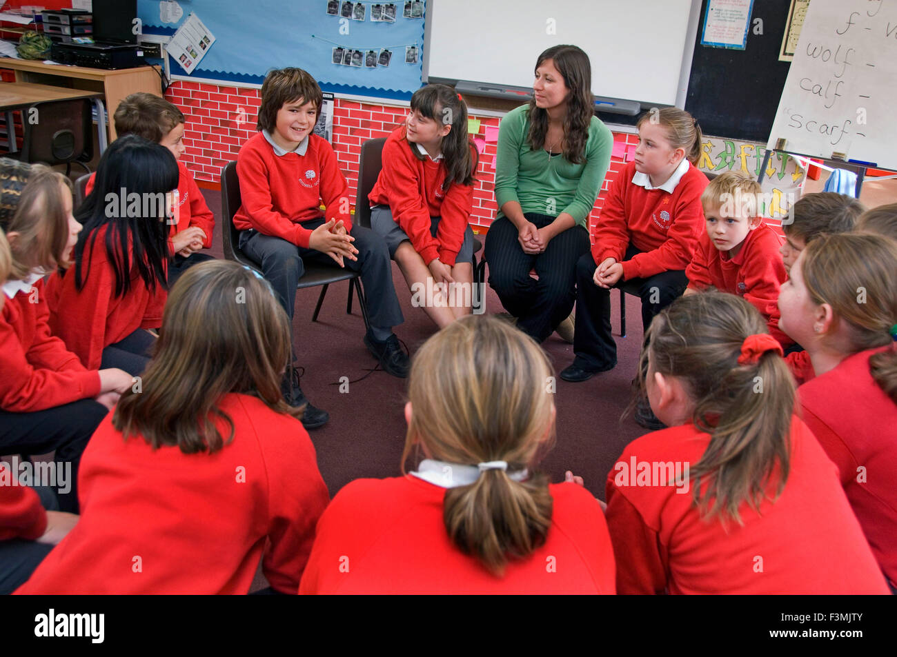 Une session d'enregistrement pour les élèves en rouge des uniformes à l'école primaire,Birdwell Aston,Bristol avec un professeur.une éducation britannique Banque D'Images