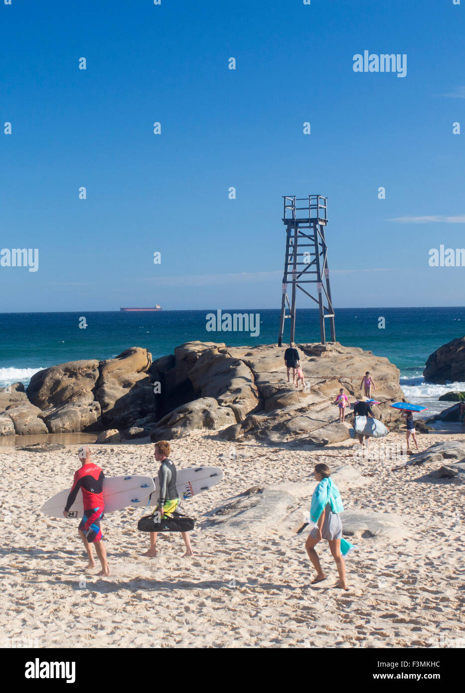 Redhead Plage surveillée tower et surfers de marcher à travers la mer de sable vers Lake MAcquarie près de Newcastle en Nouvelle-Galles du Sud EN IN Banque D'Images